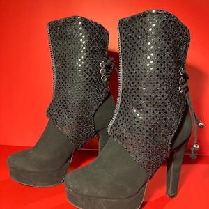 Boot covers made with black sparkle fabric. Features silver faux diamond strip down the front.