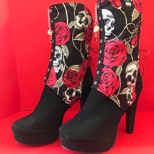 May include: Black high-heeled boots with a platform sole and a red, black and white floral print featuring roses and skulls.