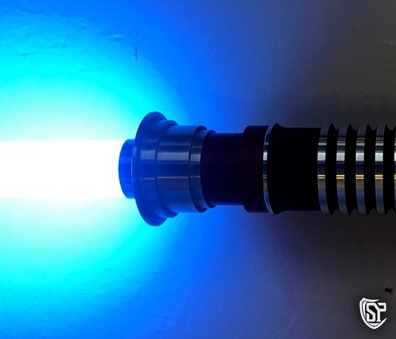 May include: A blue lightsaber with a black and silver handle. The lightsaber is turned on and emitting a bright blue beam of light.