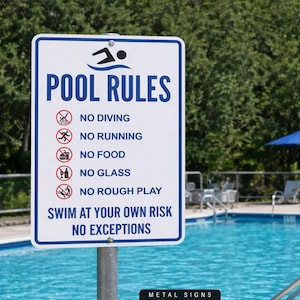May include: A rectangular white metal sign with blue text and graphics, displaying pool rules. The sign prohibits diving, running, food, glass, and rough play. It also states "Swim at your own risk, no exceptions." The sign is mounted near a pool.