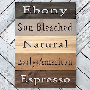 May include: Five wooden boards stained in different shades of brown. The boards are labeled "Ebony", "Sun Bleached", "Natural", "Early American", and "Espresso".