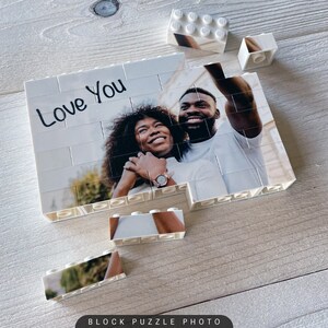 Puede incluir: Una foto de rompecabezas de bloques blancos de una pareja sonriendo y tom&aacute;ndose una selfie. El rompecabezas est&aacute; parcialmente ensamblado y las palabras "Love You" est&aacute;n escritas en la parte superior del rompecabezas.
