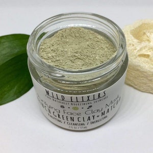 May include: A glass jar filled with green clay face mask powder. The label reads "WILD ELIXIRS PURE NATURALLY NOURISHING SKINCARE Rejuvenating Face Clay Mask FRENCH GREEN CLAY + MATCHA PURIFYING / CLEANSING / ENERGIZING 2 FL OZ / 59 ML"