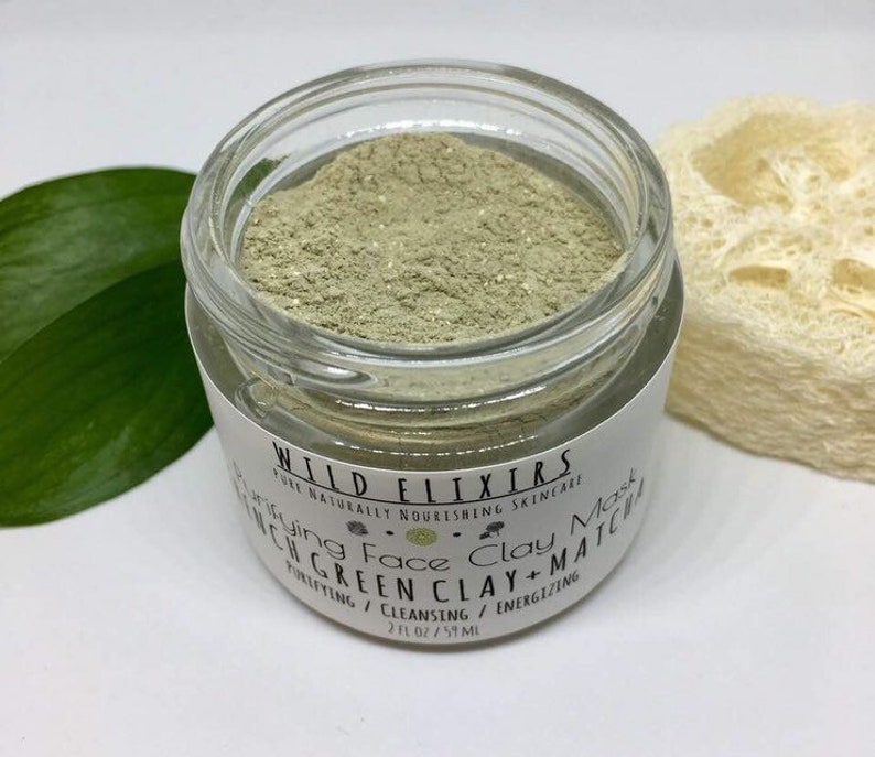 May include: A glass jar filled with green clay face mask powder. The label reads "WILD ELIXIRS PURE NATURALLY NOURISHING SKINCARE Rejuvenating Face Clay Mask FRENCH GREEN CLAY + MATCHA PURIFYING / CLEANSING / ENERGIZING 2 FL OZ / 59 ML"