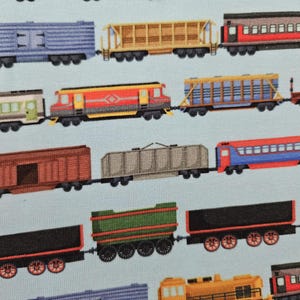 Peut inclure: Un motif répétitif de wagons de train colorés sur un fond bleu clair. Les wagons sont de différentes couleurs, notamment le bleu, le rouge, le jaune, le marron et le vert. L'image est un motif répétitif de différents types de wagons.