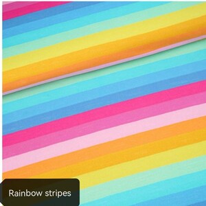 Op de afbeelding: Een levendig, kleurrijk patroon van regenboogstrepen. De afbeelding toont een diagonale rangschikking van strepen in verschillende kleuren, waaronder roze, blauw, geel en oranje. De tekst "Rainbow stripes" wordt in een zwart kader onderaan weergegeven.