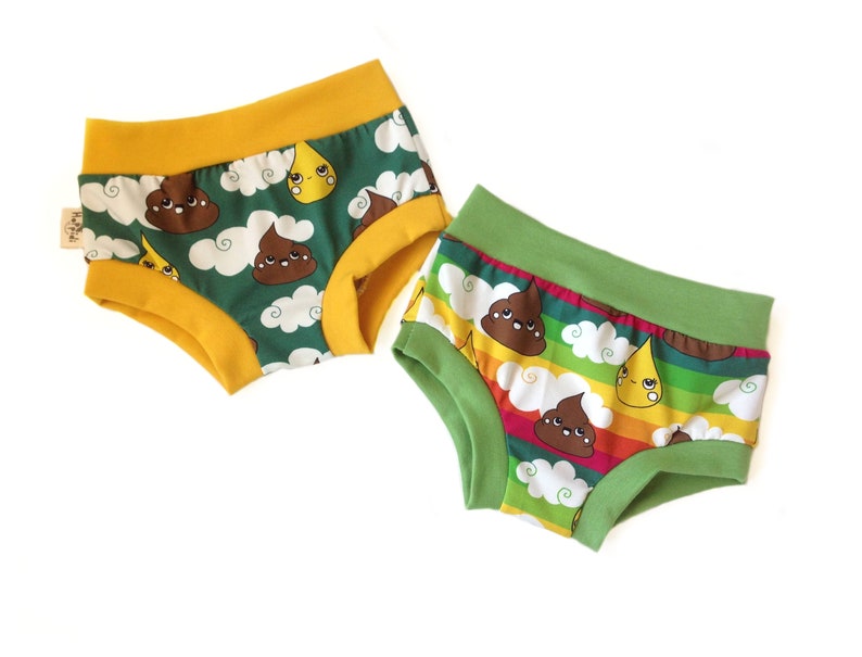 May include: Two pairs of underwear with a green and yellow background. The underwear has a print of brown poop with a face and a yellow raindrop with a face. One pair has a rainbow stripe pattern.