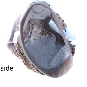 Pode incluir: Roupa interior com um painel de tecido branco com um padr&atilde;o castanho de caras de gato e pegadas, contrastado com tecido de estampado de leopardo bege. A pe&ccedil;a tem bordas bege s&oacute;lidas e a palavra Inside impressa em preto.