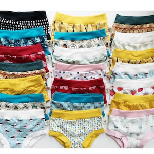 Pode incluir: Uma cole&ccedil;&atilde;o de vinte e uma pe&ccedil;as de roupa interior infantil dispostas em tr&ecirc;s colunas. Cada pe&ccedil;a apresenta um c&oacute;s el&aacute;stico largo de cor s&oacute;lida e uma variedade de padr&otilde;es coloridos, incluindo animais, frutas, formas geom&eacute;tricas e alimentos.