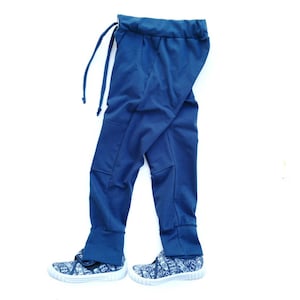 May include: A pair of dark blue sweatpants with a drawstring waist and cuffed legs. The sweatpants are laying flat on a white surface.