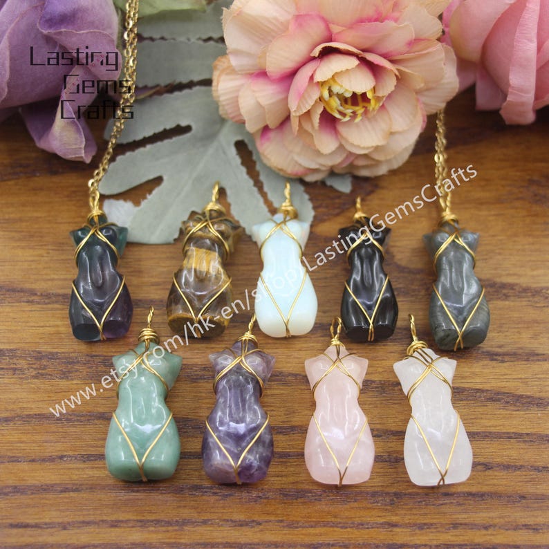 May include: Eight different colored gemstone pendants in the shape of a female torso, each wrapped in gold wire. The pendants are arranged in a row on a wooden surface. The text "www.etsy.com/hk-en/shop/LastingGemsCrafts" is visible in the image.