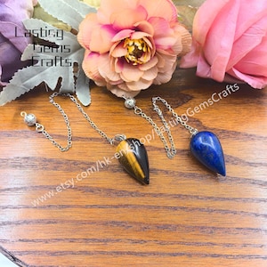 May include: Two crystal pendulums with chains. One is tiger's eye with brown and gold stripes, the other is blue lapis lazuli.  www.etsy.com/hk-en/shop/LastingGemsCrafts