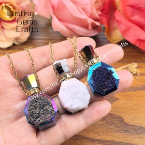May include: Three gemstone pendant necklaces with gold-colored chains. The pendants are hexagonal-shaped bottles with different colored crystal formations inside. The bottles are held in a hand. The text "Lasting Gems Crafts" and a website address are visible.