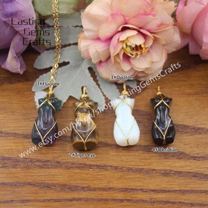 May include: Four gold-wrapped wire pendants with different gemstone figures. The pendants are labeled 1#Fluorite, 2#Tiger eye, 3#Opalite, and 4#Obsidian. The pendants are displayed on a wooden surface.