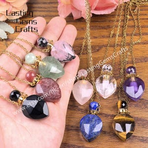 Può includere: Una collezione di collane con ciondoli di pietre preziose in vari colori, tra cui rosa, verde, viola e nero. Ogni ciondolo ha una forma unica ed è appeso a una catena d'oro. Il testo "Lasting Gems Crafts" è visibile.