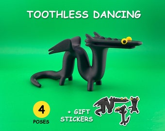May include: Black 3D printed Toothless dragon figurine from How to Train Your Dragon, in a dancing pose. The figurine has yellow eyes and is on a green background. The image also includes a text overlay that says "TOOTHLESS DANCING" and "4 POSES + GIFT STICKERS".