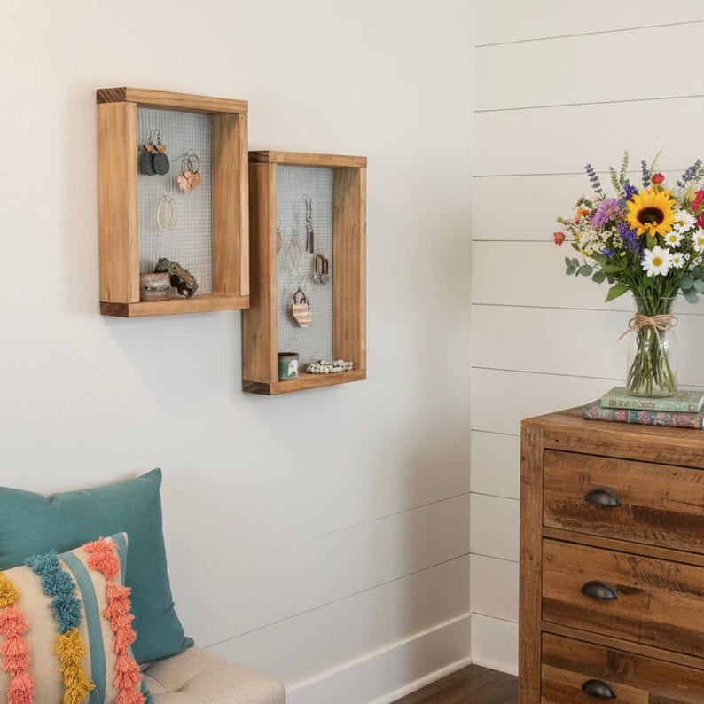 May include: Two rectangular wooden wall-mounted organisers featuring a wire mesh backing. Each frame is constructed from light brown wood and serves as a display for hanging various earrings and small accessories within the grid structure.