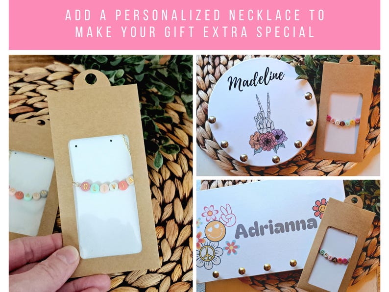 May include: Personalized necklaces with colorful letter beads on thin chains, presented in brown cardboard packaging. The display includes white cards featuring the names Madeline and Adrianna, alongside graphic illustrations of a skeleton hand, flowers, and smiley faces.