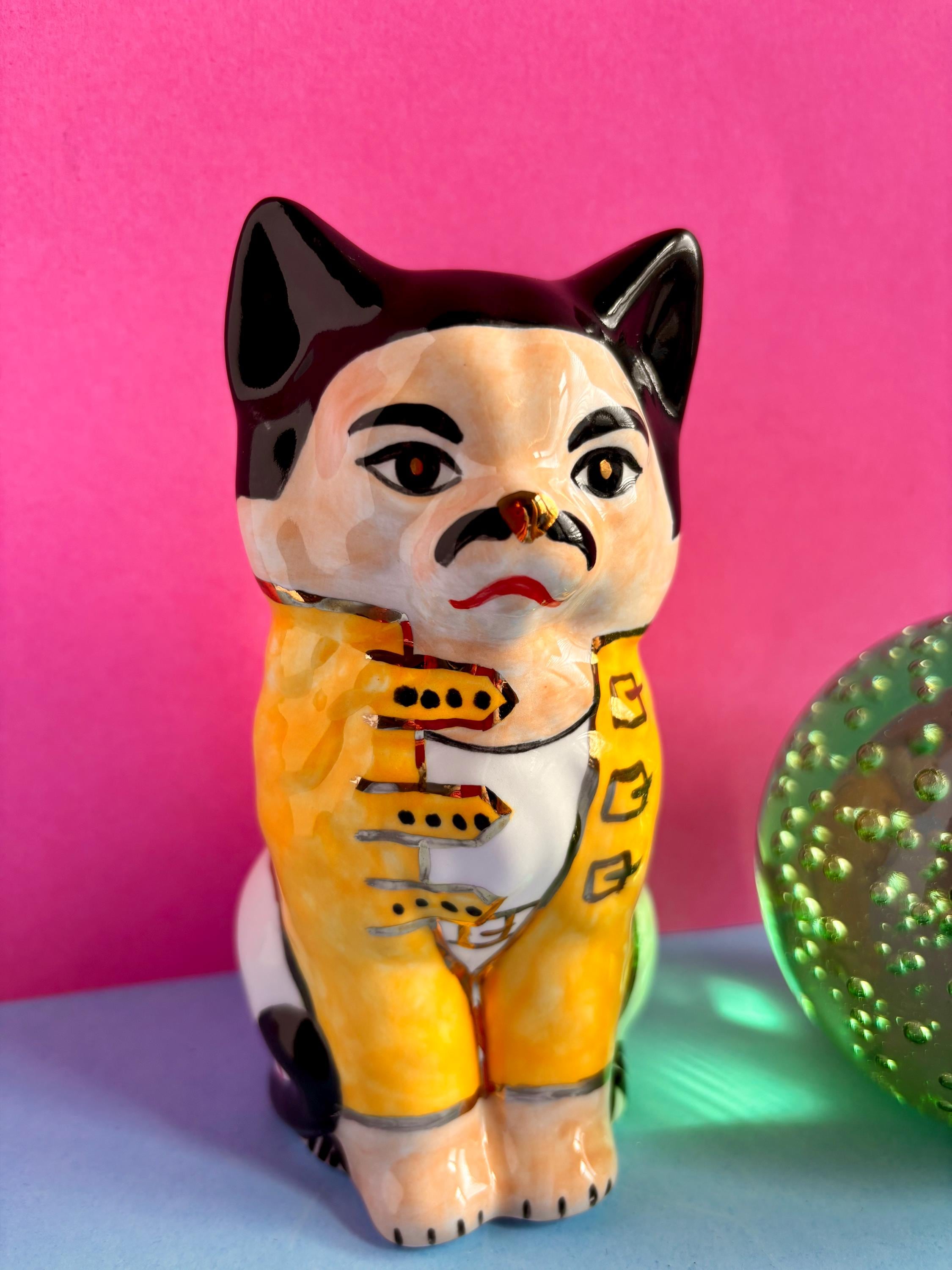 フレディ・ミャウキュリーの陶器製置物：金色の光沢を施した手作りの猫 