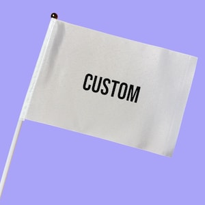 May include: A small white flag with the word "CUSTOM" printed in black. The flag is attached to a white pole with a small gold-colored ball at the top. The background is a solid light purple color.