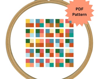 May include: A PDF pattern for a cross stitch project featuring a colorful geometric design of squares in various shades of yellow, orange, red, blue, green, and brown. The pattern is displayed in a wooden embroidery hoop.