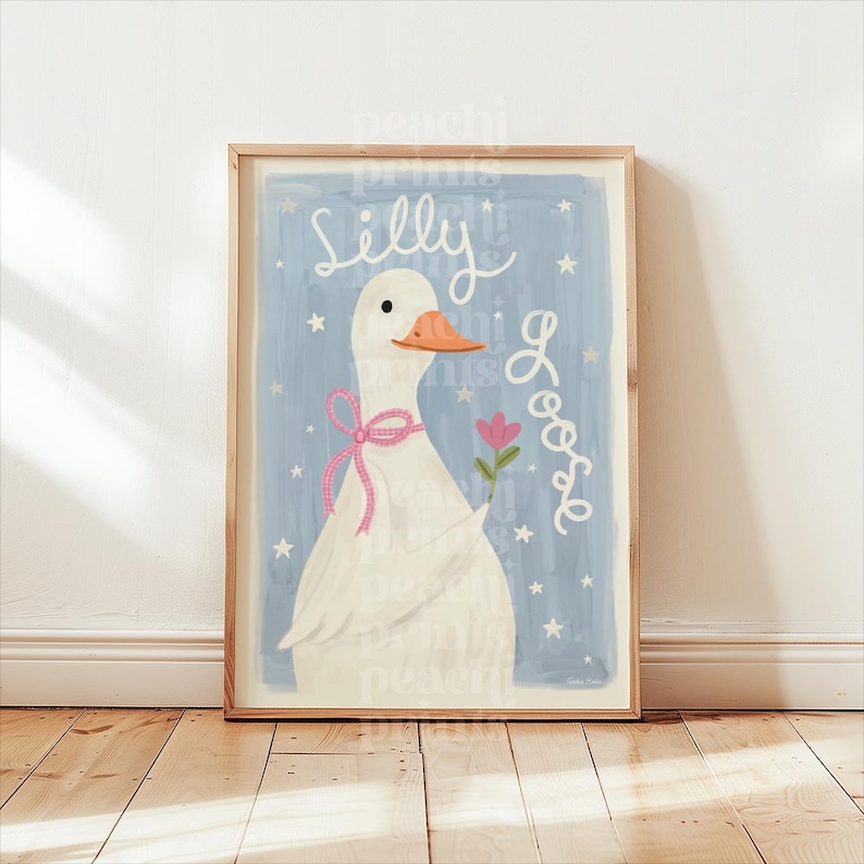 May include: A framed art print featuring a whimsical illustration of a white goose with an orange beak and a pink bow. The goose holds a pink flower against a light blue background with the words "Silly Goose" in white script and stars.