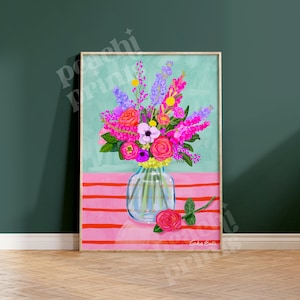 Pode incluir: Um buqu&ecirc; de flores coloridas em um vaso de vidro transparente sobre um fundo listrado rosa e vermelho. As flores incluem flores rosa, roxas, vermelhas e amarelas.