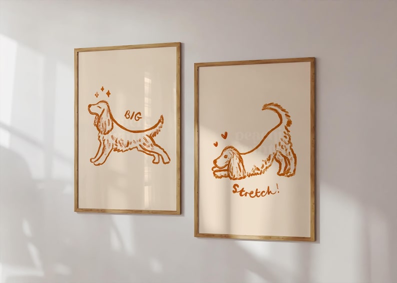 May include: Two framed art prints featuring line drawings of a dog in a playful pose. One print has the word "BIG" and sparkles, the other says "Stretch!" with hearts. The artwork is in shades of brown on a cream background.