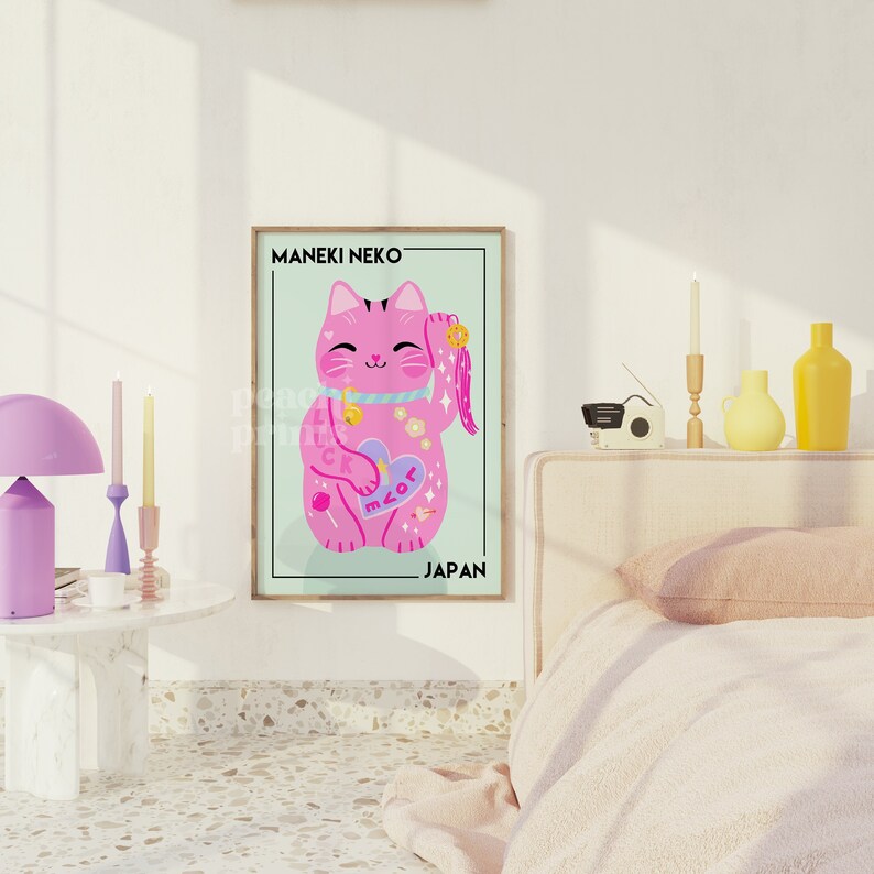 Puede incluir: Un Maneki Neko rosa, un gato de la suerte japon&eacute;s, con una pata levantada, sosteniendo un coraz&oacute;n con la palabra "miau" en &eacute;l. El gato est&aacute; rodeado de detalles coloridos, incluyendo una piruleta, una estrella y una luna creciente. El p&oacute;ster tiene el texto "MANEKI NEKO" y "JAP&Oacute;N" en &eacute;l.