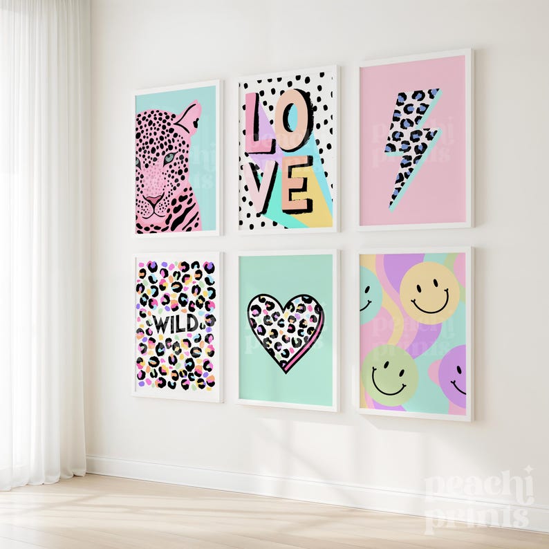 May include: Six framed art prints with colorful designs. The prints feature a leopard, the word "LOVE", a lightning bolt, the word "WILD", a heart, and smiley faces. Each print has a white frame and is mounted on a white wall.