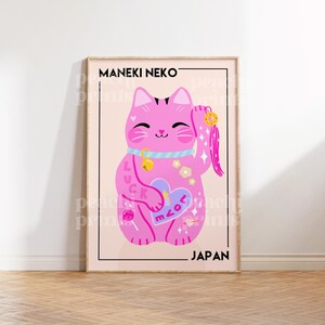 Puede incluir: Un Maneki Neko rosa, un gato japon&eacute;s de la suerte, con un coraz&oacute;n y las palabras "Love" y "Luck" en su cuerpo. El gato sostiene una moneda de oro y tiene una borla rosa. El texto "MANEKI NEKO" y "JAPAN" est&aacute;n en la parte superior e inferior de la imagen.