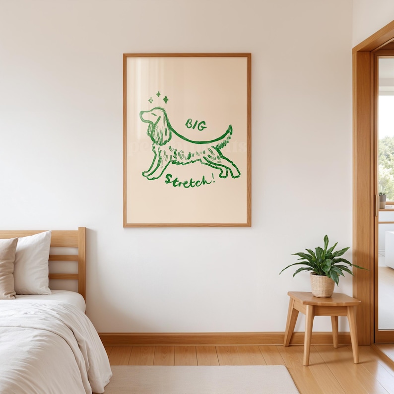 May include: A framed print featuring a green illustration of a dog in a stretching pose. The words "BIG Stretch!" are written in green. The artwork is displayed on a cream-colored background within a wooden frame.