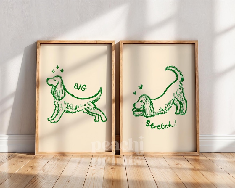 May include: Two framed art prints with a light beige background. Each print features a green line drawing of a dog. One print says "BIG" and the other says "Stretch!". The frames are made of light brown wood.