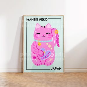 Puede incluir: Un Maneki Neko rosa, o gato de la suerte, con una pata levantada, est&aacute; representado en un estilo de dibujos animados. El gato tiene un collar azul con una campana, un coraz&oacute;n rosa con la palabra "love" en &eacute;l y la palabra "luck" en su brazo. El gato est&aacute; sobre un fondo azul claro con la palabra "JAPAN" en la parte inferior.