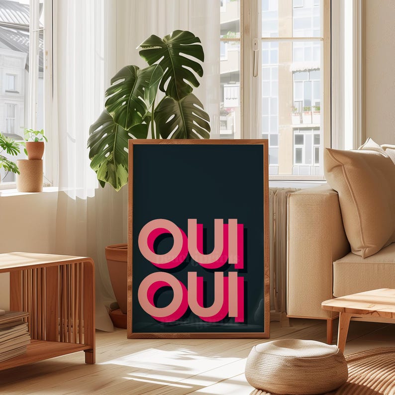 May include: A rectangular framed wall art piece featuring a dark charcoal background with the word OUI repeated twice in a stacked layout. The letters are rendered in a bold, layered pink and light coral typography with a distinct drop shadow effect.