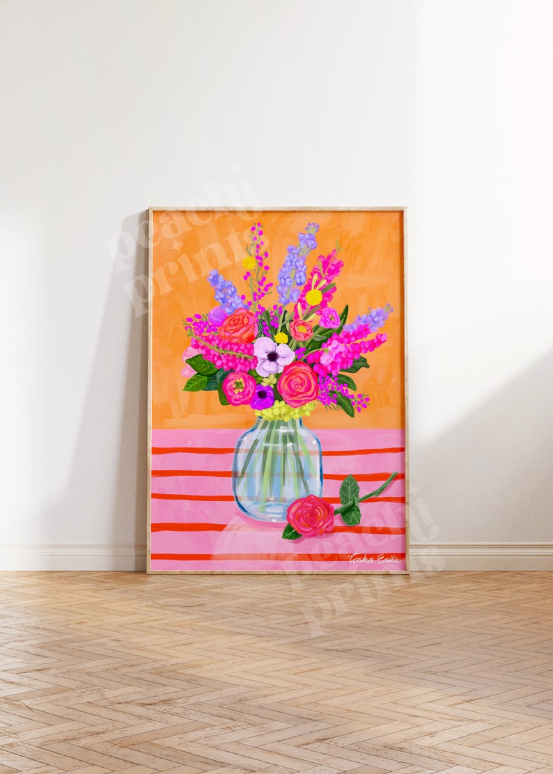 Pode incluir: Um buqu&ecirc; colorido de flores rosa, roxas e brancas em um vaso de vidro transparente sobre um fundo listrado rosa e laranja. O vaso est&aacute; sobre uma superf&iacute;cie rosa com uma &uacute;nica rosa rosa ao lado. O texto "Tasha Evanko" est&aacute; no canto inferior direito da imagem.