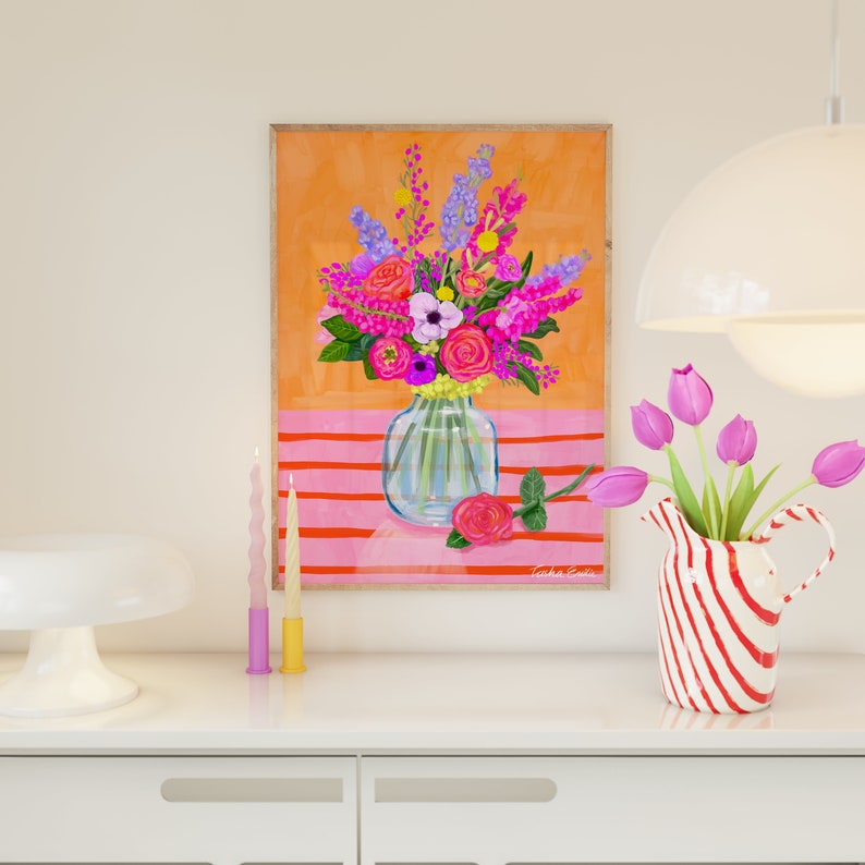 Pode incluir: Uma ilustra&ccedil;&atilde;o emoldurada de um buqu&ecirc; de flores rosa, roxas e brancas em um vaso de vidro transparente sobre um fundo listrado rosa e laranja. O texto "Tasha Evins" est&aacute; no canto inferior direito da imagem.