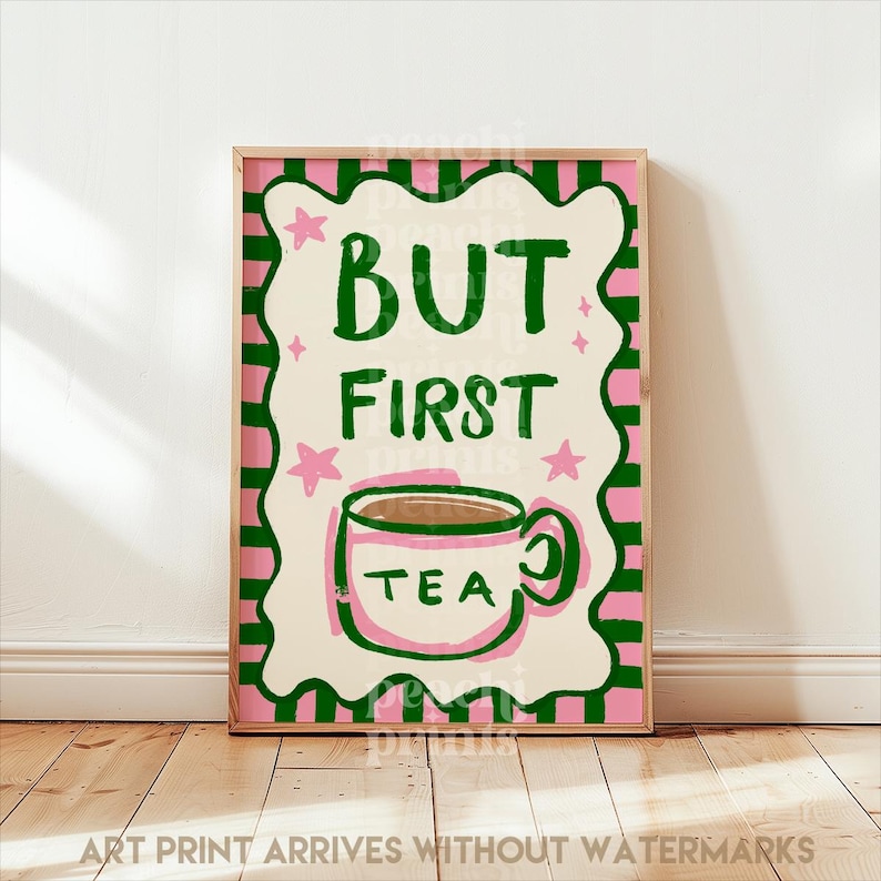 May include: A framed art print with a pink and green border. The print features the words "BUT FIRST TEA" in green, with a teacup illustration. Pink stars and a decorative border surround the text. The phrase "ART PRINT ARRIVES WITHOUT WATERMARKS" is at the bottom.
