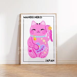 Puede incluir: Un Maneki Neko rosa, un gato japon&eacute;s de la suerte, con una pata levantada, sosteniendo un coraz&oacute;n con la palabra "love" en &eacute;l. El gato tiene un collar azul con una campana y est&aacute; decorado con flores, estrellas y una piruleta. El texto "MANEKI NEKO" y "JAP&Oacute;N" est&aacute;n en la parte superior e inferior de la imagen.