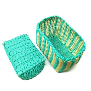 May include: Two woven plastic storage baskets with a green and yellow striped pattern. The baskets are empty and are sitting on a white background.