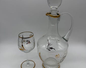 Juego de decantador y copa de vino de cristal grabado vintage con diseño floral en oro y plata.