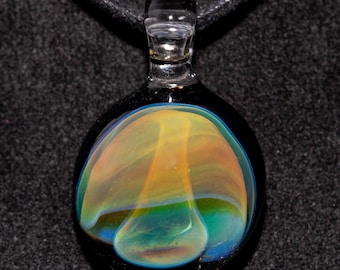 May include: A clear glass pendant with a black background. The pendant has a teardrop shape with a colorful interior of yellow, orange, green, and blue hues. A black cord is attached to the pendant.