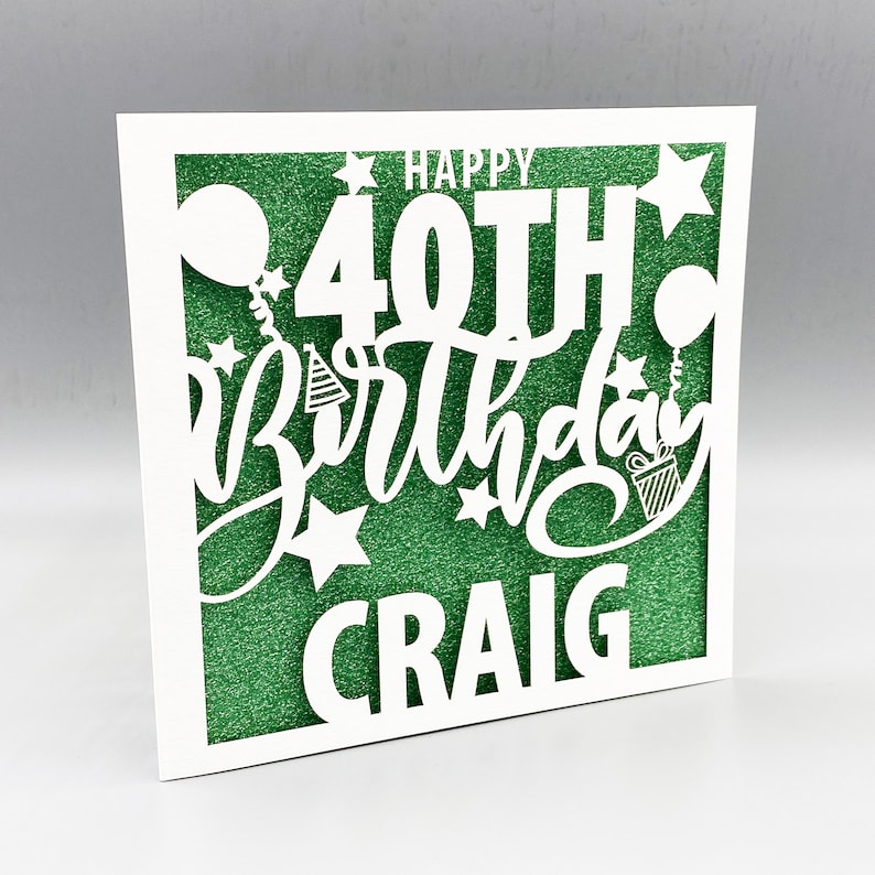 May include: White card with a green glitter background. The card has a white cut-out design that says "Happy 40th Birthday Craig".