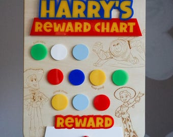May include: A rectangular wooden reward chart featuring the text HARRY'S REWARD CHART in blue and yellow acrylic, with engraved character illustrations, colourful acrylic circles, and the word REWARD in red and yellow acrylic at the bottom.