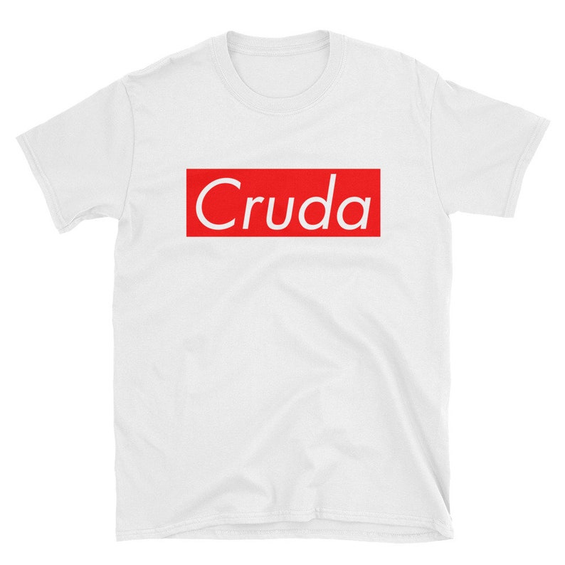 May include: White t-shirt with a red box and the word "Cruda" in white text.