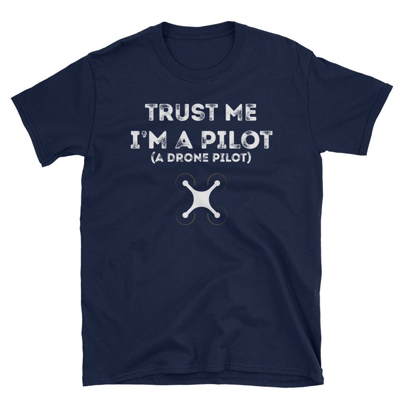 May include: A navy blue t-shirt with the text "TRUST ME I'M A PILOT (A DRONE PILOT)" in white. A white drone icon is below the text.