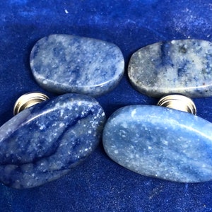 May include: Four oval-shaped blue and white stone cabinet knobs with silver metal bases.