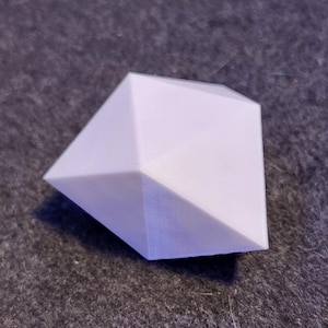 Puede incluir: Una forma geométrica blanca impresa en 3D que se asemeja a un diamante.