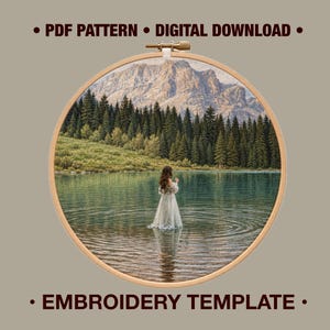 May include: A circular wooden embroidery hoop containing a printed fabric image of a person in a long dress standing in a lake before a forest and mountains. The text PDF PATTERN DIGITAL DOWNLOAD and EMBROIDERY TEMPLATE is printed on the background.