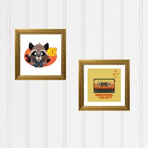 May include: Two framed prints, one with a cartoon raccoon character saying "HO!" and the other with a retro cassette tape with the text "Awesome Mix Vol. 1" and "Guardians of the Galaxy".